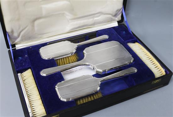 A cased George V Art Deco engine turned silver six piece dressing table set, William Comyns & Sons Ltd, London, 1935.